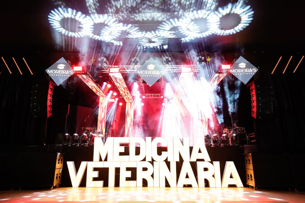 Palco iluminado da formatura com o letreiro do curso e a marca Moreira's
